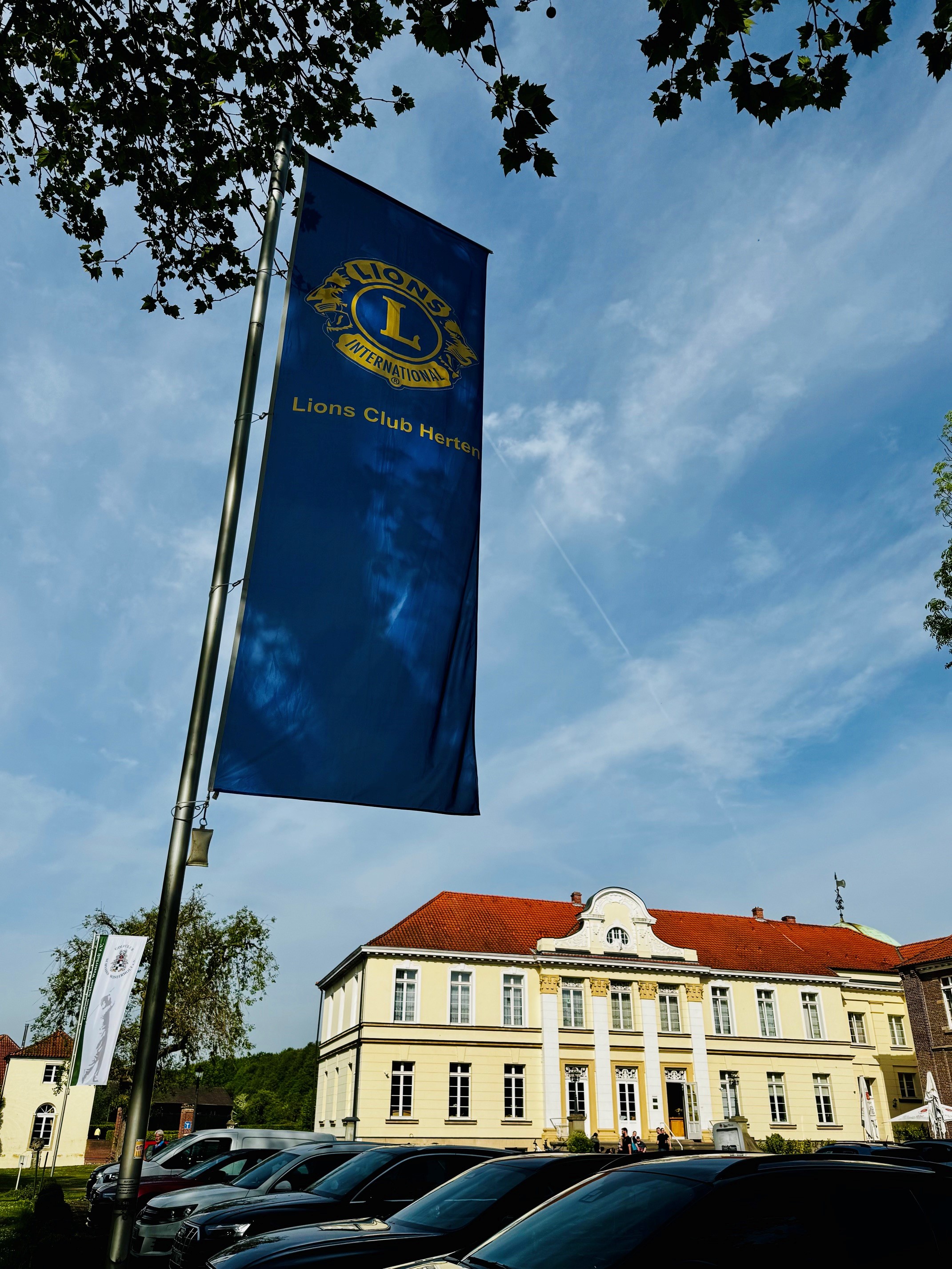 Das Foto zeigt eine Flagge des Lions Clubs Herten vor dem Schloss Hotel Westerholt