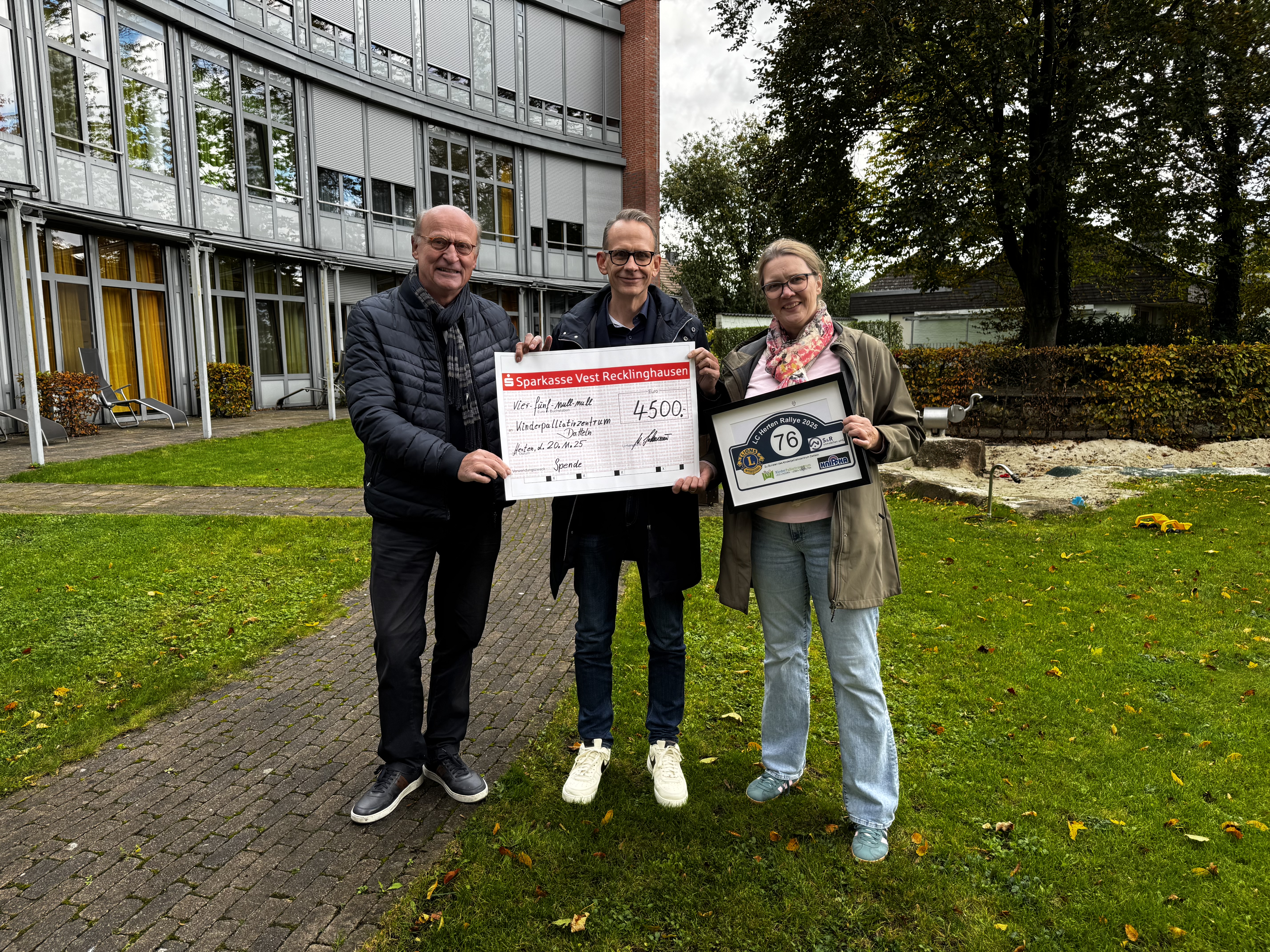Das Foto zeigt Frau Nicole Sasse vom Freundeskreis Kinderpalliativzentrum Datteln e.V. gemeinsam mit Harald Korf und Michael Lackmann beide vom Lions Club Herten bei der Spendenübergabe vor dem Gebäude des Kinderpalliativzentrum in Datteln