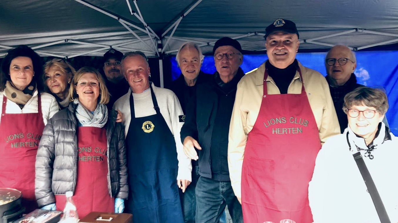 Das Foto zeigt ein Gruppenbild einiger Lions am Wein und Flammkuchen Verkaufsstand auf dem Ernte- und Bauernmarkt in Recklinghausen Hochlar im Jahr 2025