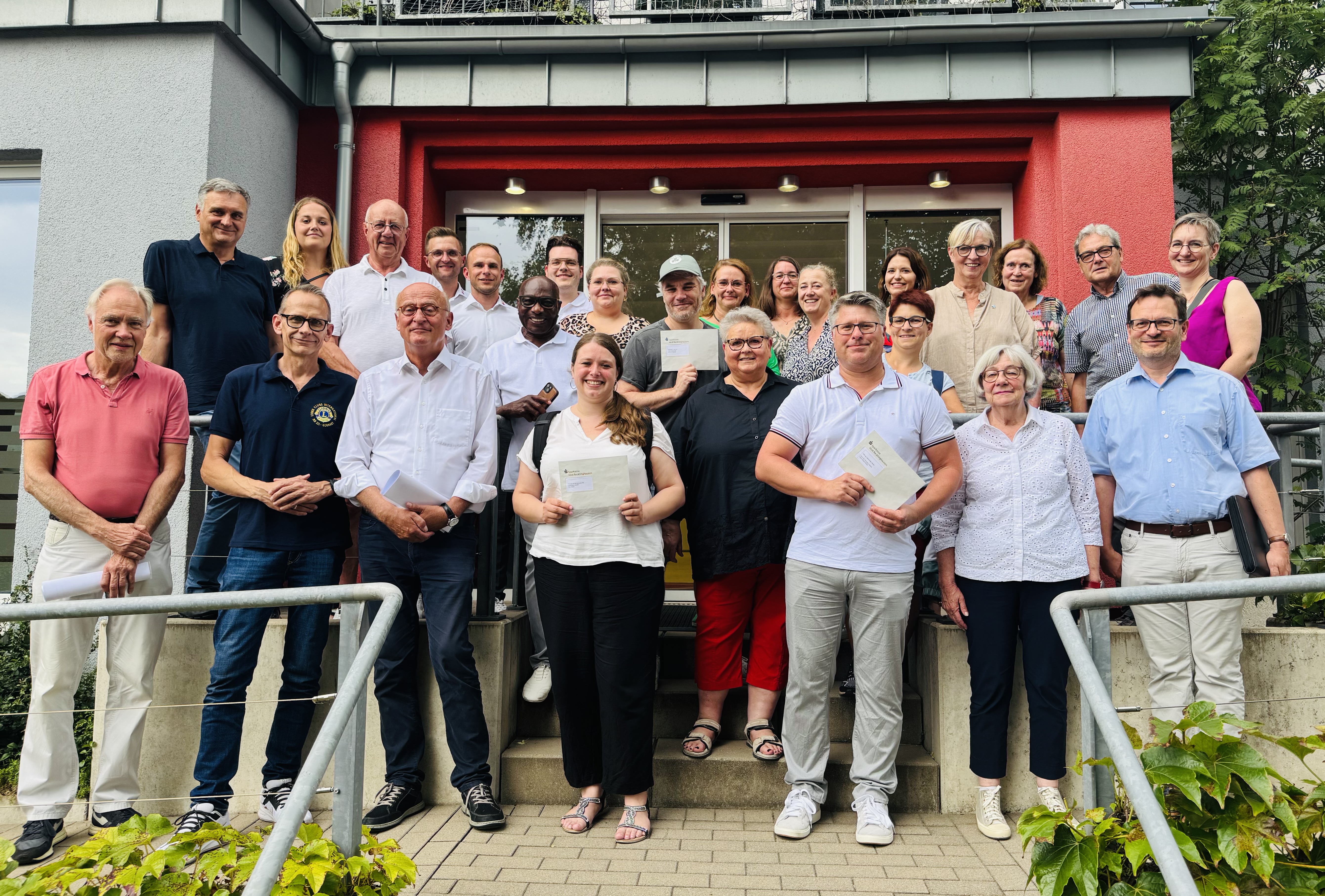 Das Foto zeigt ein Gruppenbild bei der bei der Veranstaltung zur Spendenübergabe vor dem Gebäude des DRK in Herten. Zu sehen sind einige Mitglieder der Lions gemeinsam mit den Vertretern der Spendenempfängern.